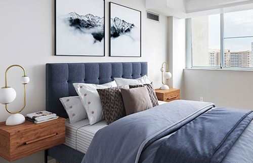 Staged bedroom with queen-sized bed and stunning city-view.