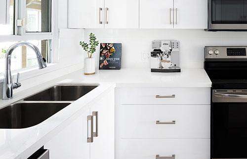 Inside the kitchen, finishes are clean and white, and stainless steel appliances command the space.