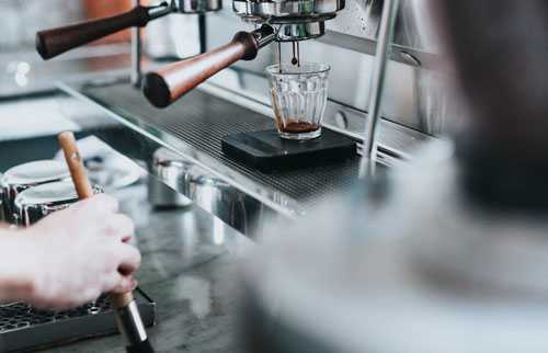 Espresso being poured into glass at local coffee shop
