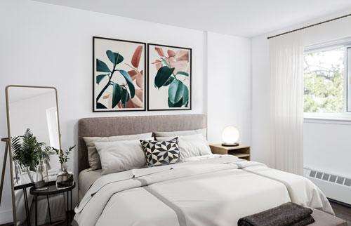 Staged, spacious bedroom with night stand and mirror