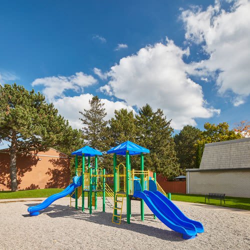 Kids playground area with slide and sandy area.