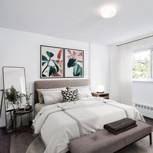 Staged, spacious bedroom with night stand and mirror