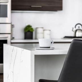 a white table with a cup of coffee on it at Altaire, Arlington