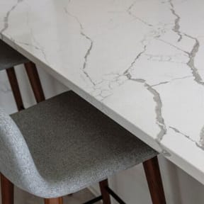 a white table with a gray chair under it at Altaire, Arlington