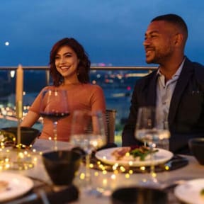 a man and woman sitting at a table with wine glasses at Altaire, Arlington, Virginia
