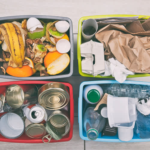A collection of recyclable materials including cans, plastic bottles, and paper.