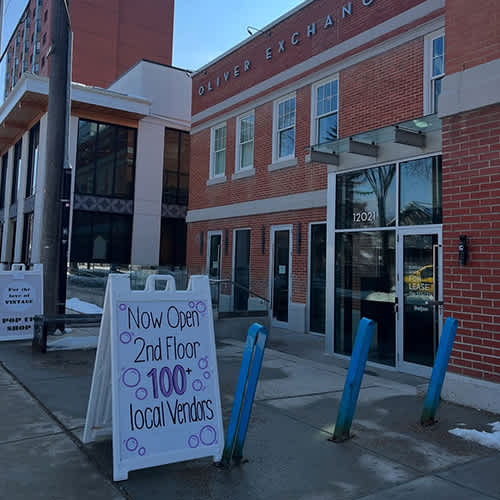 Oliver Exchange building with a sign that says "Now Open 2nd Floor 100+ local vendors".