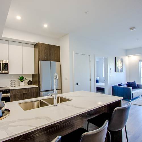 A modern kitchen with a white countertop and a sink.