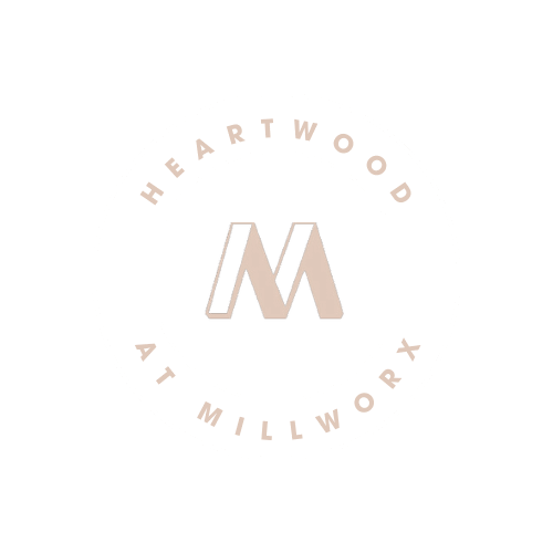 A logo with a circle and the words "Heartwood At Millwork" written inside it.