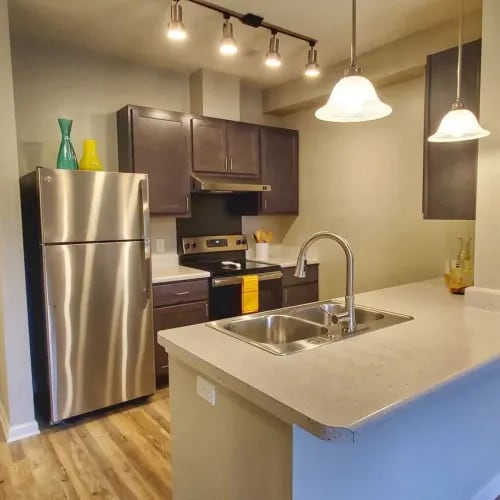 A kitchen with a stainless steel refrigerator and a sink.