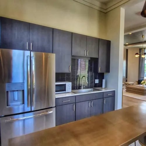 A modern kitchen with a wooden table and stainless steel appliances.