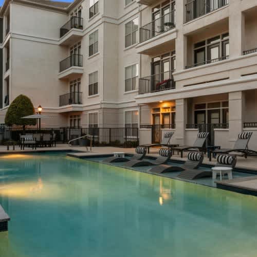 A large, modern apartment building with a pool in front.