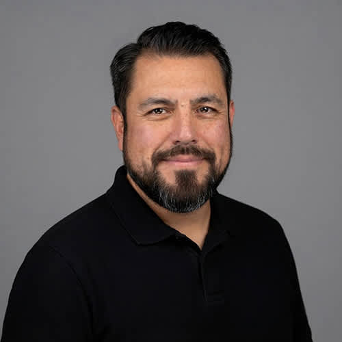 A man with a beard and mustache wearing a black shirt.