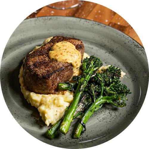 A plate of food with broccoli, mashed potatoes and meat.