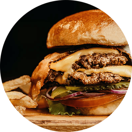 a cheeseburger with a side of fries on a wooden table