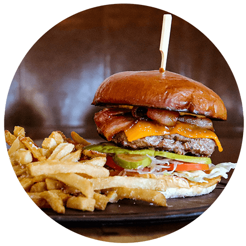 a hamburger and fries on a wooden plate