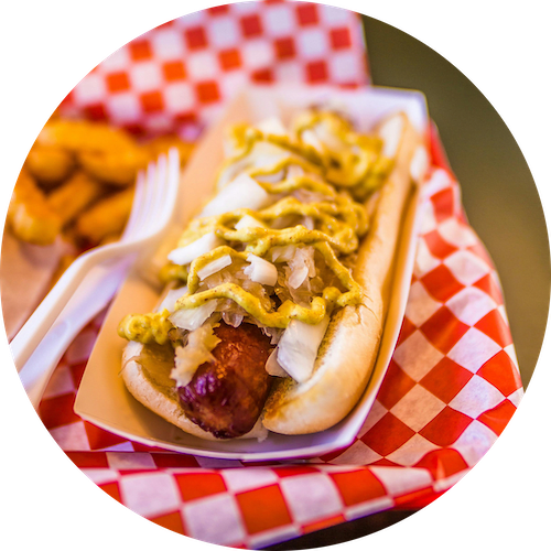 a hot dog with mustard and cole slaw on a paper