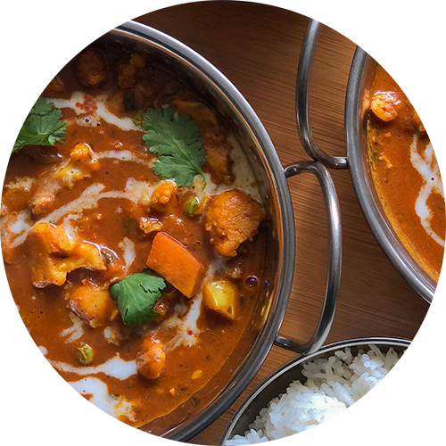 a pot of curry and a bowl of rice on a table