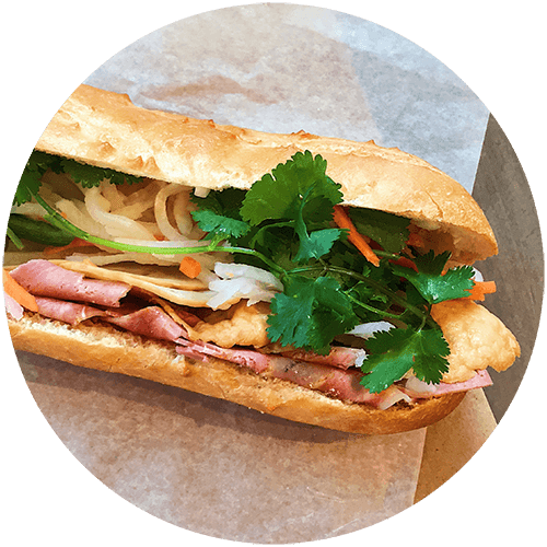 a sandwich with meat and vegetables on a bun