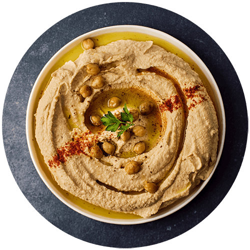 a bowl of hummus with olive oil and parsley