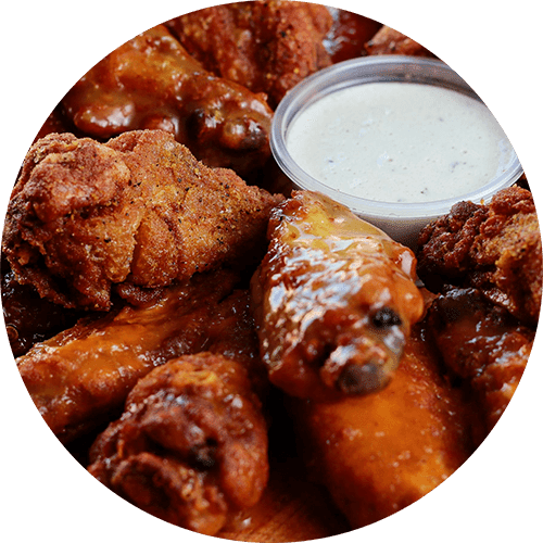 Fried chicken wings with a side of dipping sauce.