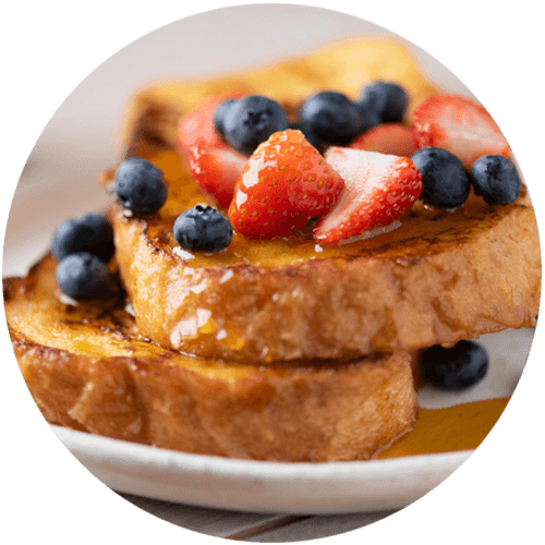 A plate of French toast topped with strawberries and blueberries.