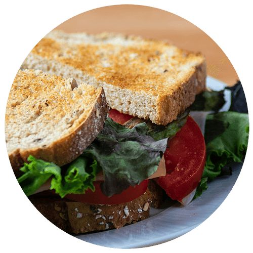 a sandwich with lettuce and tomatoes on a plate