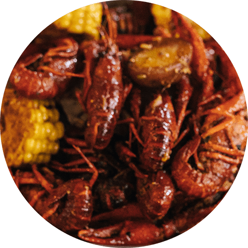 a plate of food with crawfish and corn on the cob