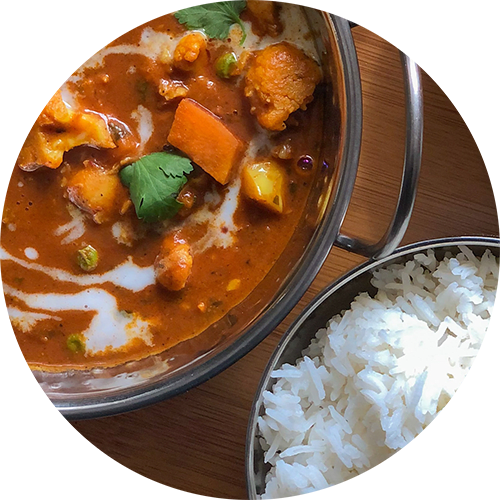 a bowl of rice and a pot of curry on a table