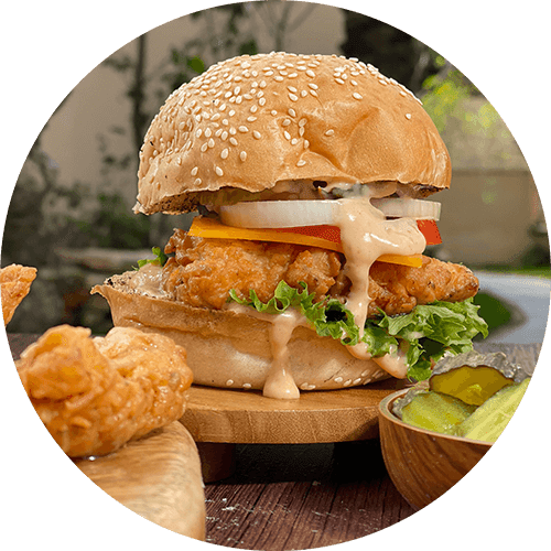 a fried chicken sandwich on a wooden cutting board with chips