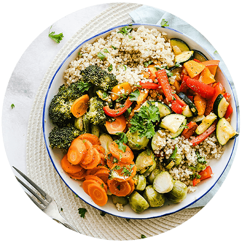 a bowl of rice and vegetables with a fork on a table