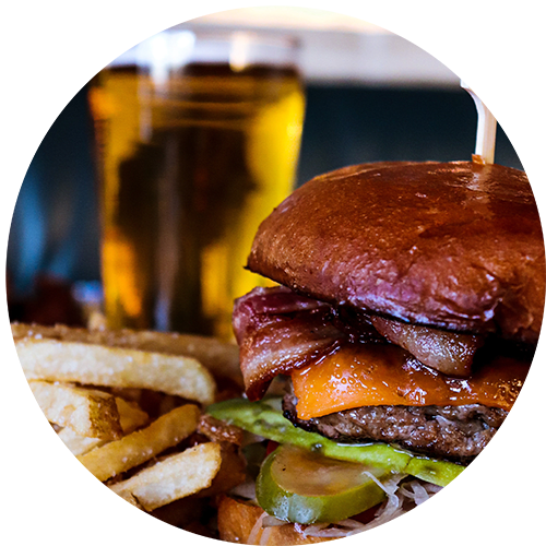 a hamburger and fries with a glass of beer