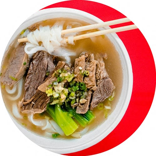 a bowl of beef noodle soup with chopsticks
