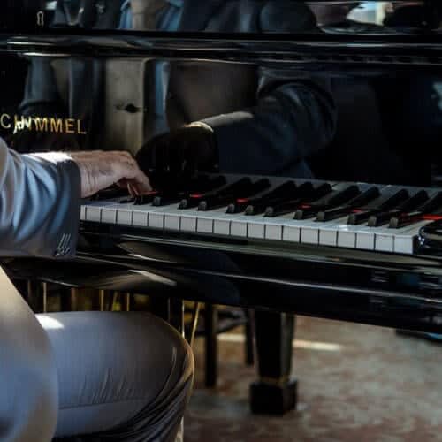 a person playing a piano on a stool at Altaire, Arlington, VA