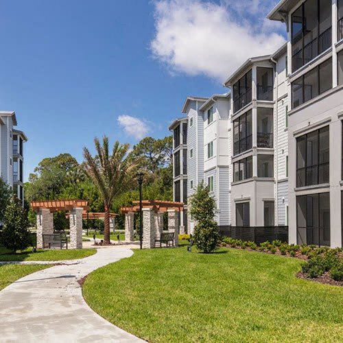 a group of people sitting around a table taking a picture with a tablet at Enclave at 3230 Apartments, South Daytona, 32119