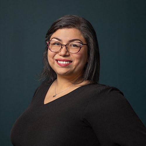 a woman wearing glasses and a black shirt