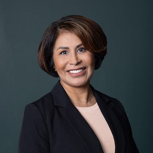 a woman wearing a black suit and smiling at the camera