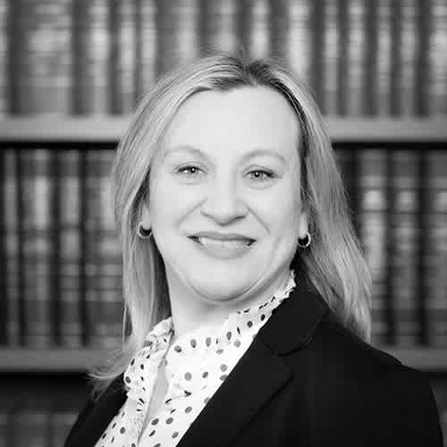 a woman with short hair wearing a black shirt and a tie
