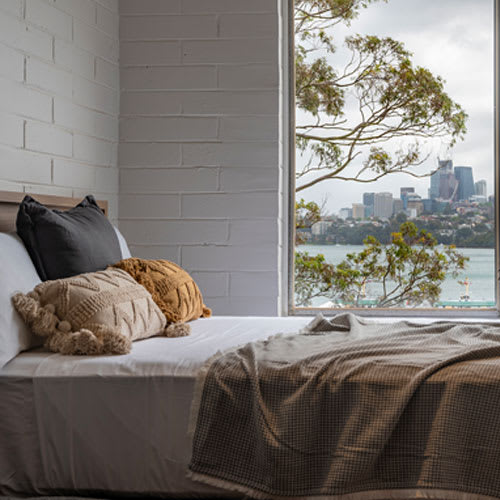 a bedroom with a bed and a window overlooking the water