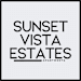 A black and white image of a sign for Sunset Vista Estates Apartments.