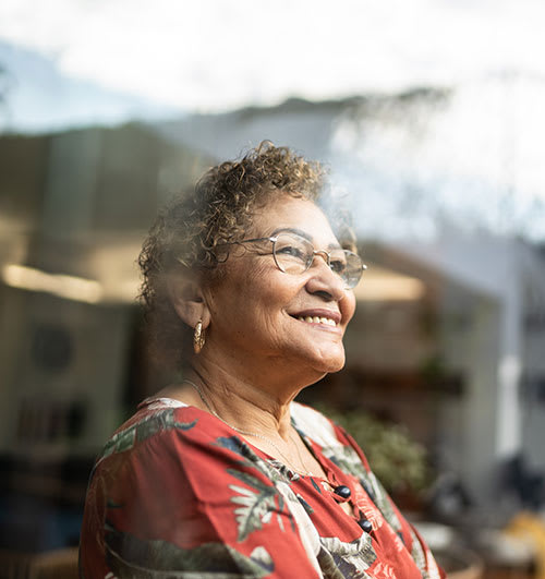 a woman in a red shirt and glasses smiling