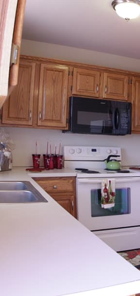 a kitchen with white cabinets and a black stove and refrigerator