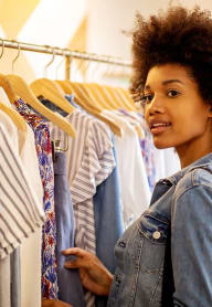 a woman looking at clothes on a rack
