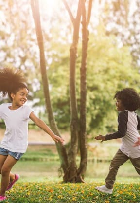 kids running in the grass at FIRE TOWER Apartments, HELENA, MT