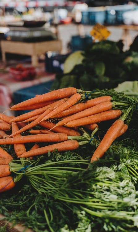 a pile of carrots and greens on a table at Mark at 87 Apartments, Arizona, 85201