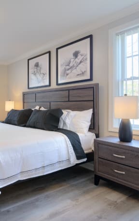 a bedroom with a bed and a dresser with a lamp on it