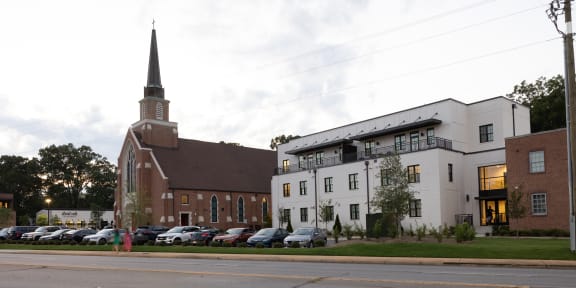 a city street with a church and a building with a parking lot