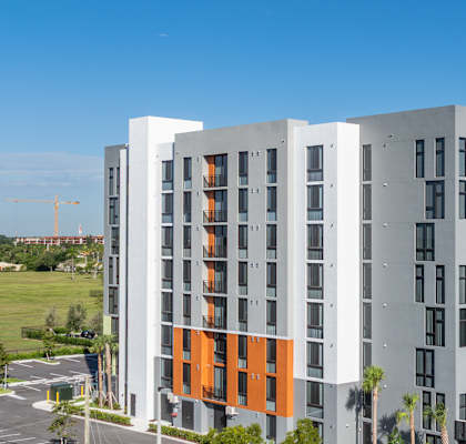 A modern multi-story building with orange and grey accents.