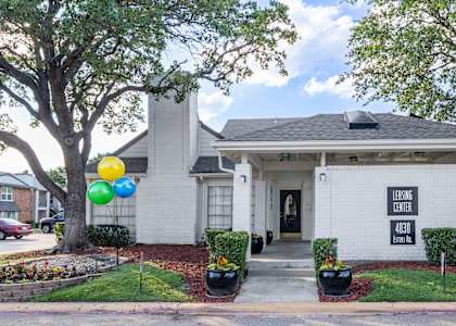 the front of a white house with balloons