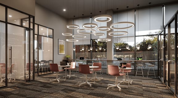 A modern office space with glass walls and hanging lights.
